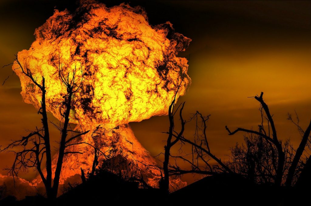 Imagem de uma explosão em formato de bola de fogo no meio de um cerrado.