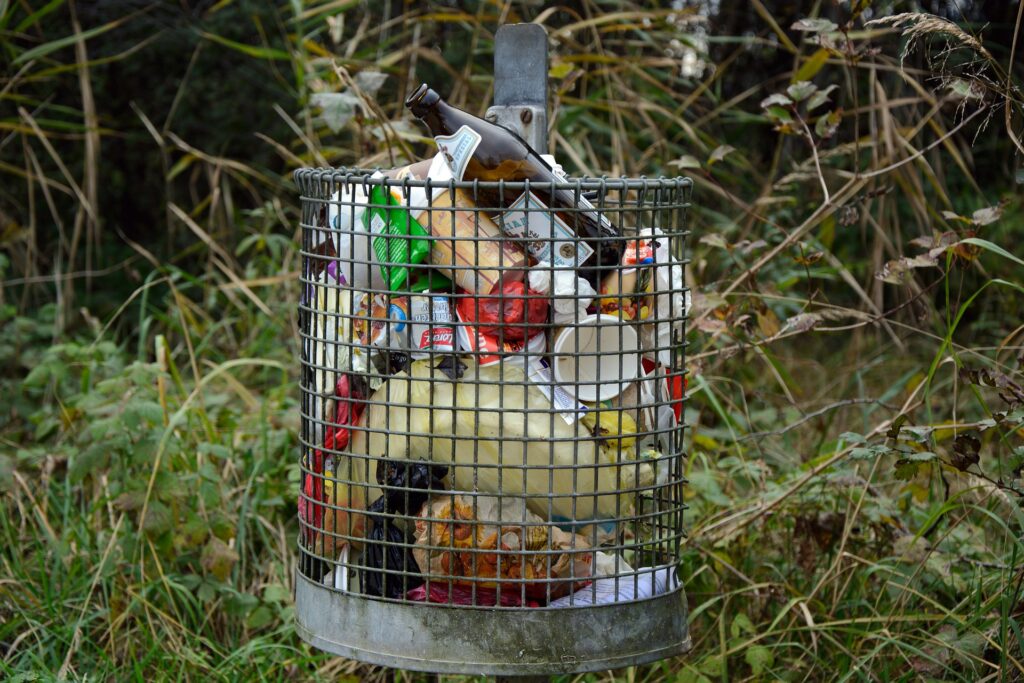 Cesto de aramo cheio de resíduos domésticos prontos para serem reciclados.
