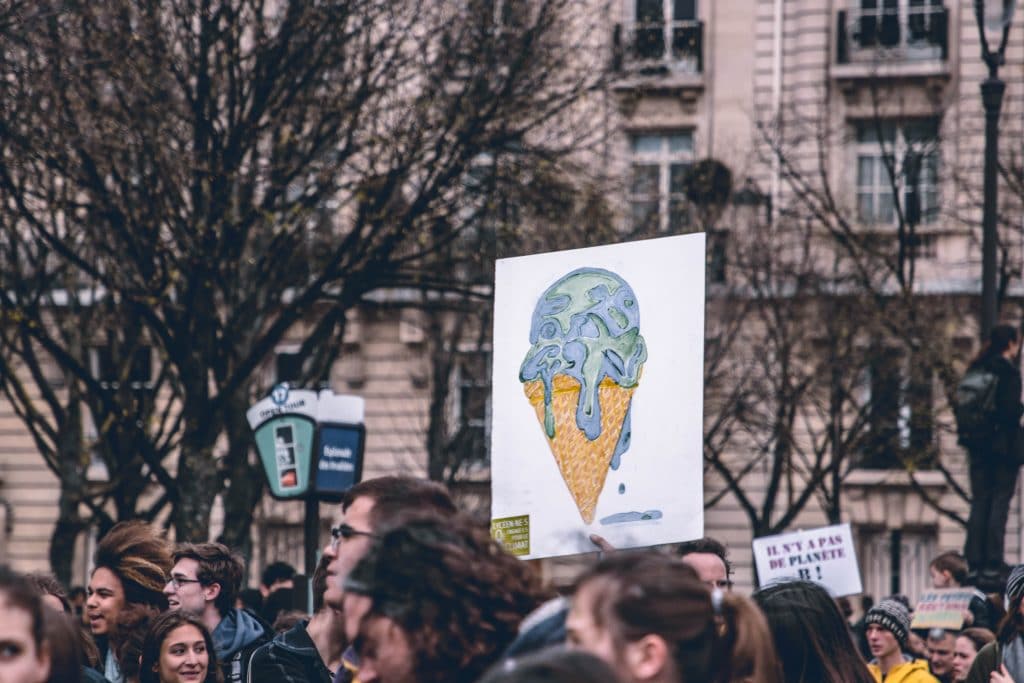 Cartaz levantado em um protesto de rua, representando o planeta Terra como uma casquinha de sorvete derretendo.