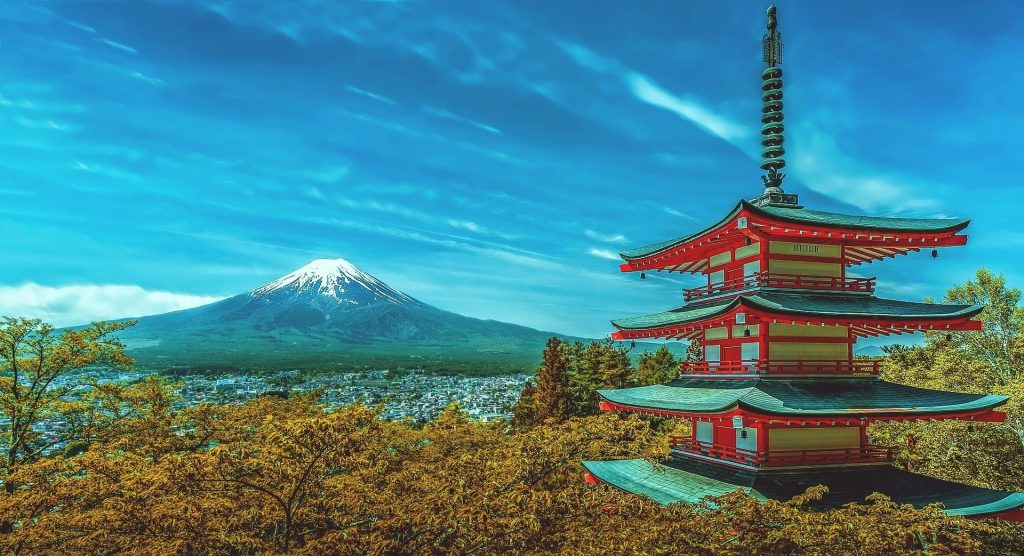 Imagem de um lindo tempo japonês nas cores branco e vermelho. Ao fundo o monte fuji coberto com a neve.
