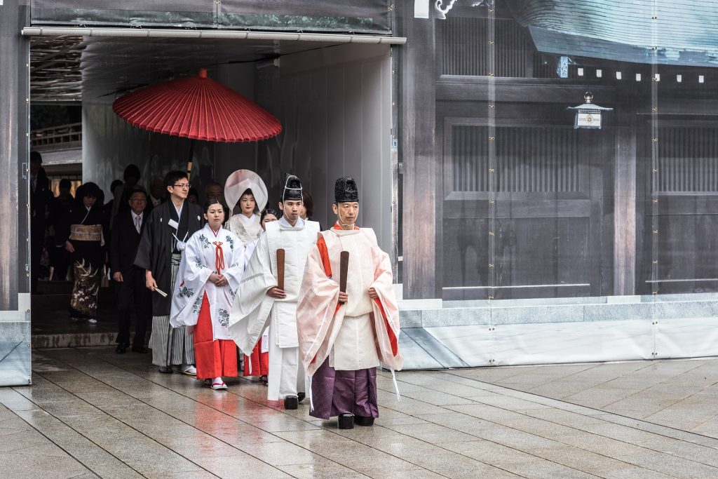 Vários japoneses saindo de uma cerimônia realizada em um famoso templo budista. 