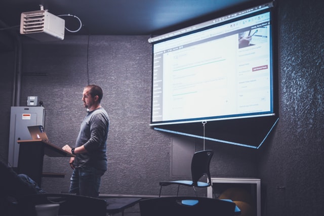 Homem apresentando com Slide e notebook