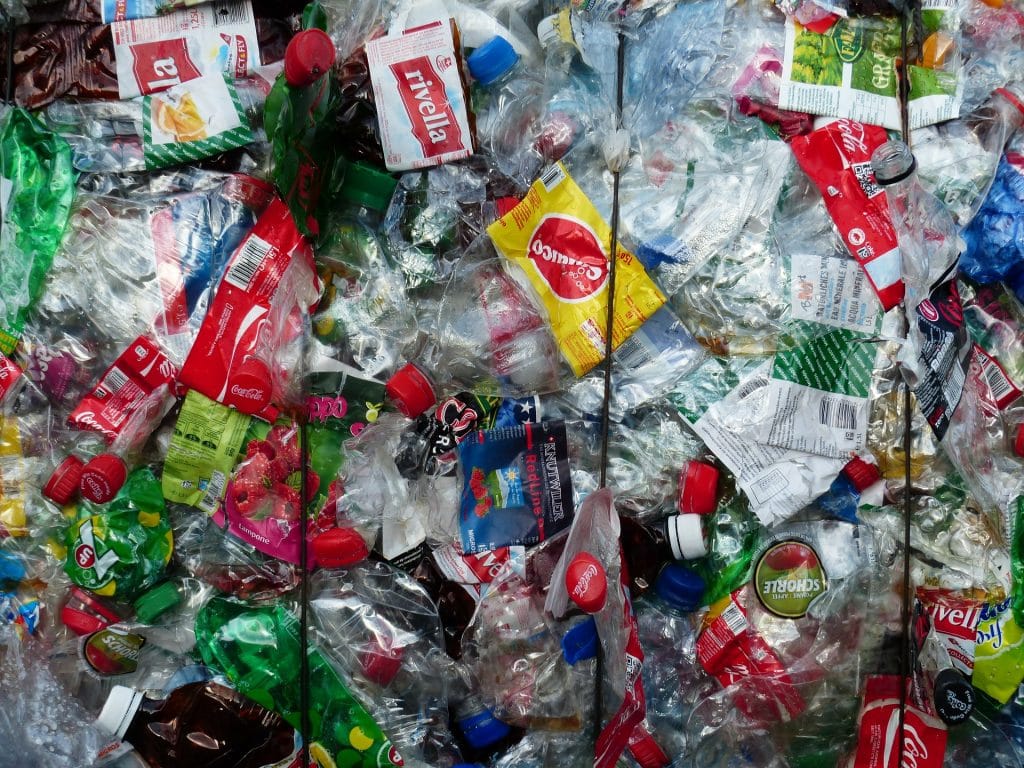 Imagem de várias garrafas pláticas prontas para serem recicladas.
