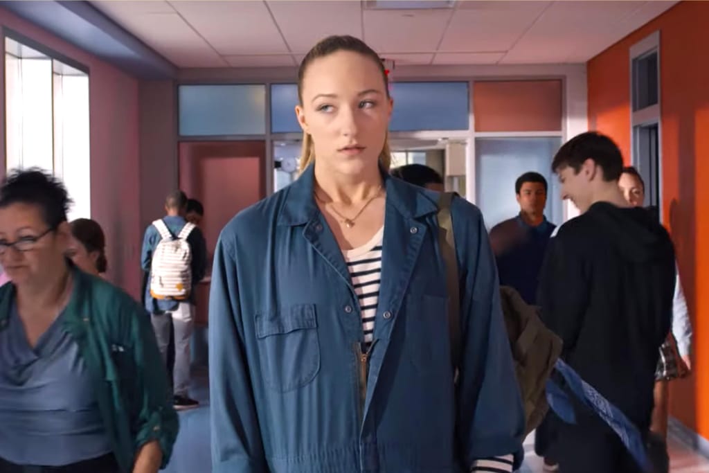 Cena do filme "Crush à altura", em que a personagem principal caminha pelo corredor da escola, aflita e insegura.