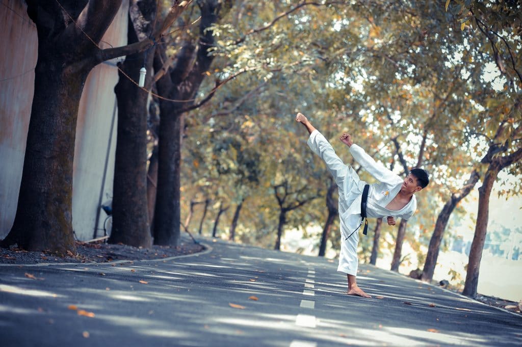 Homem praticando artes marciais no meio da rua