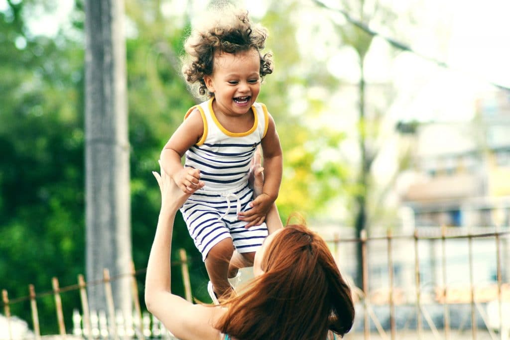 Mulher colocando criança no ar enquanto ri