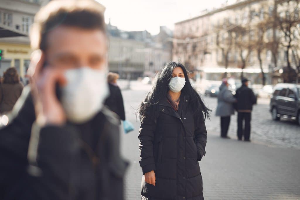 Pessoas usando máscaras na rua.