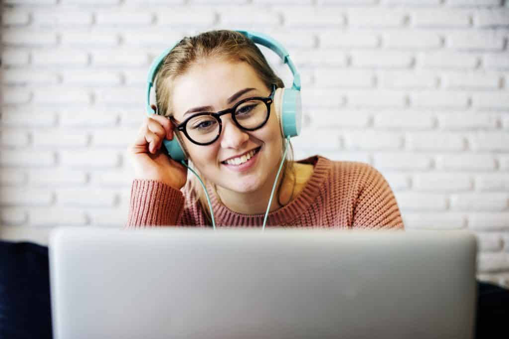 Mulher fazendo vídeo chamada com seu notebook e seu fone