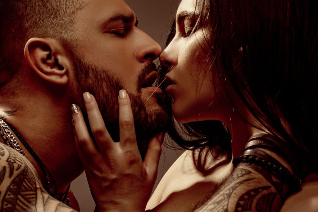 Imagem de um casal (homem e mulher) se beijando sensualmente.