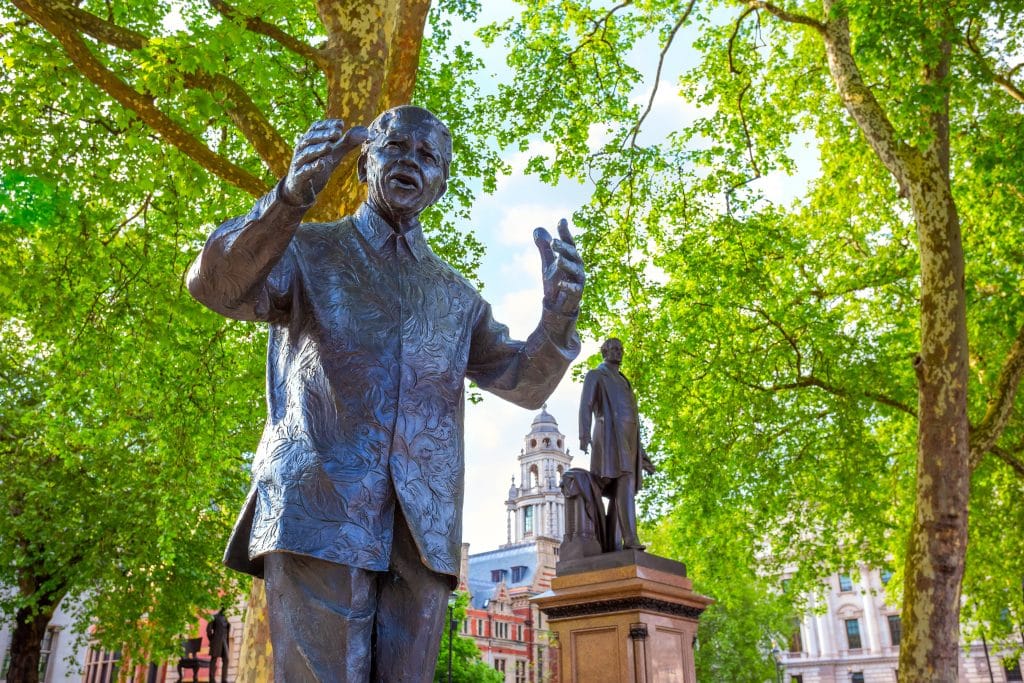 Imagem da estátua de Nelson Mandela instalada em uma praça pública.