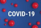 "COVID-19" escrito entre ilustrações de virus.