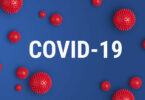 "COVID-19" escrito entre ilustrações de virus.