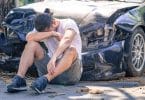 Homem triste chorando após acidente de carro.