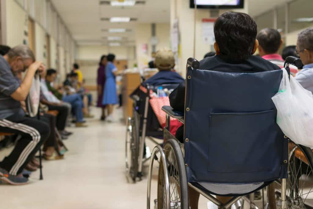 Paciente esperando doutor em uma sala de espera com muitas pessoas