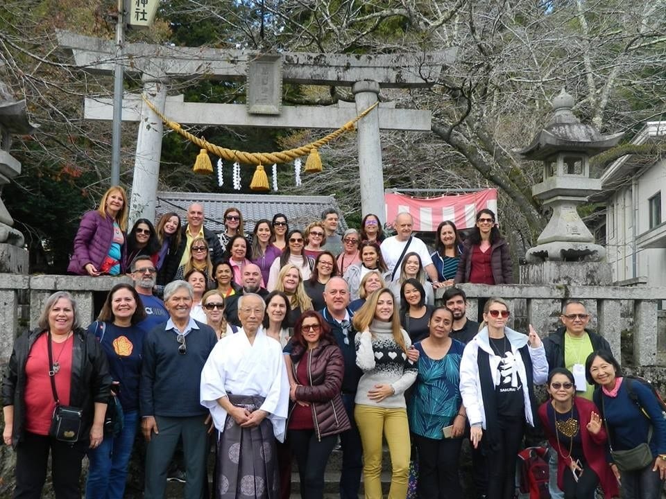 Grupo de pessoas posando para foto em frente a um templo.