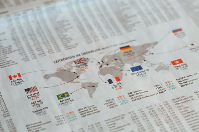 Folha com mapa mundi e bandeiras de países com valores comerciais