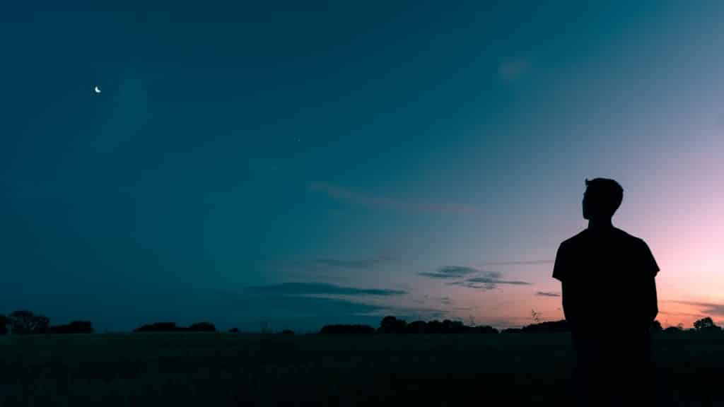 Silhueta de um homem olhando para a natureza a noite