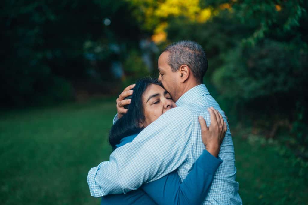 Homem e mulher se abraçando em um jardim