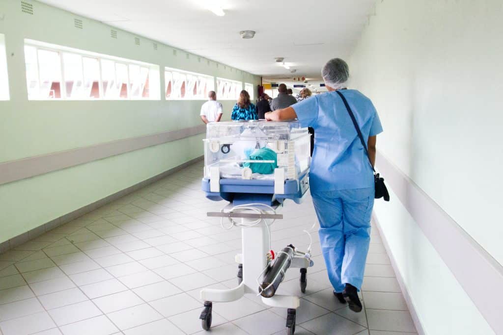 Enfermeira andando pelo corredor do hospital
