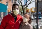 Casal na rua usando máscara de proteção