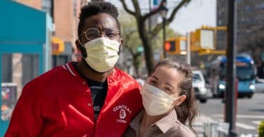 Casal na rua usando máscara de proteção