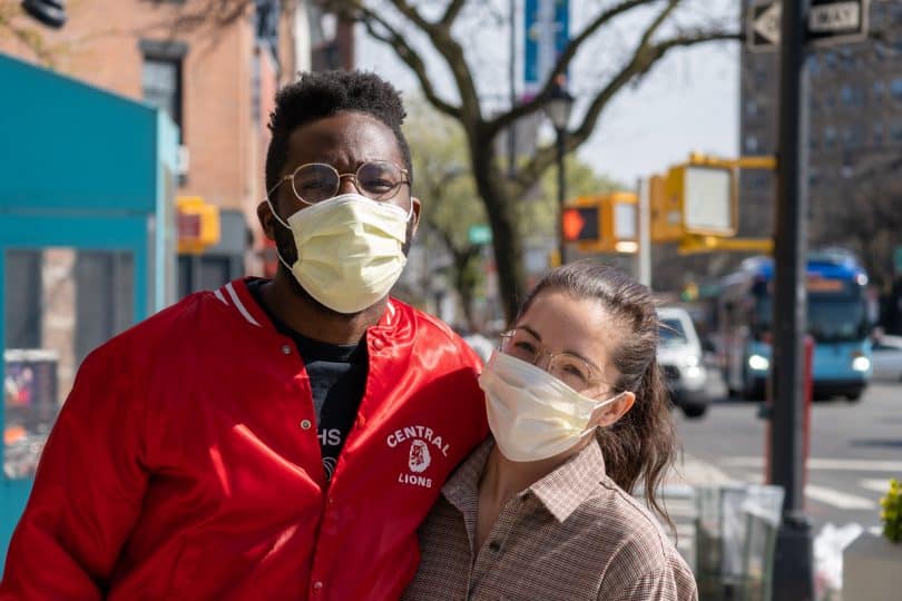 Casal na rua usando máscara de proteção