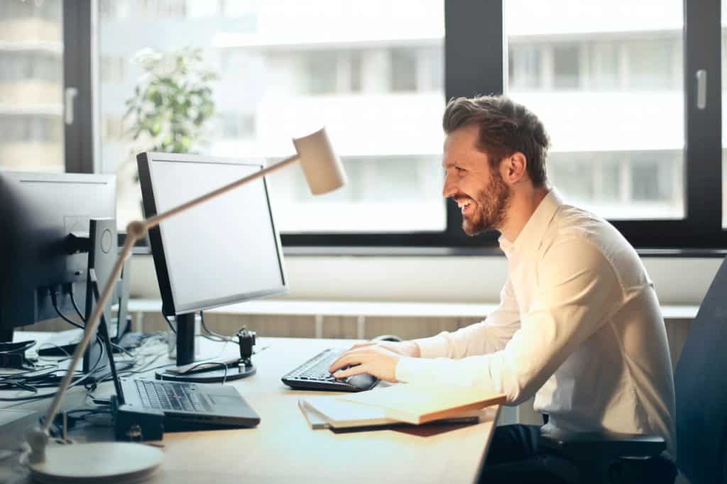 Homem em escritório, usando um computador.