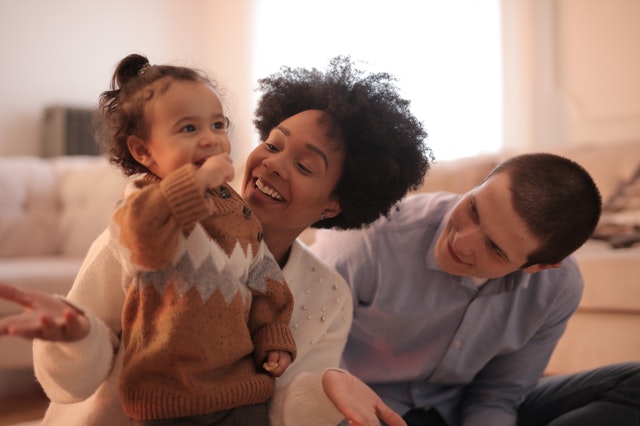 Família em sala de casa brincando sendo bebê, mãe e pai