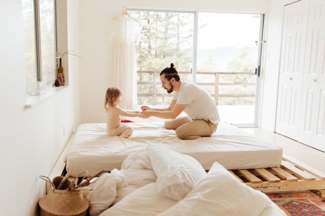 Pai e filha brincando na cama