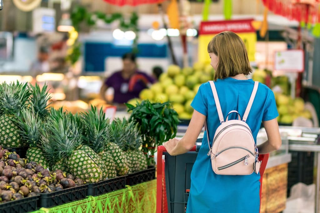 Mulher fazendo compras em um supermercado, na seção de frutas