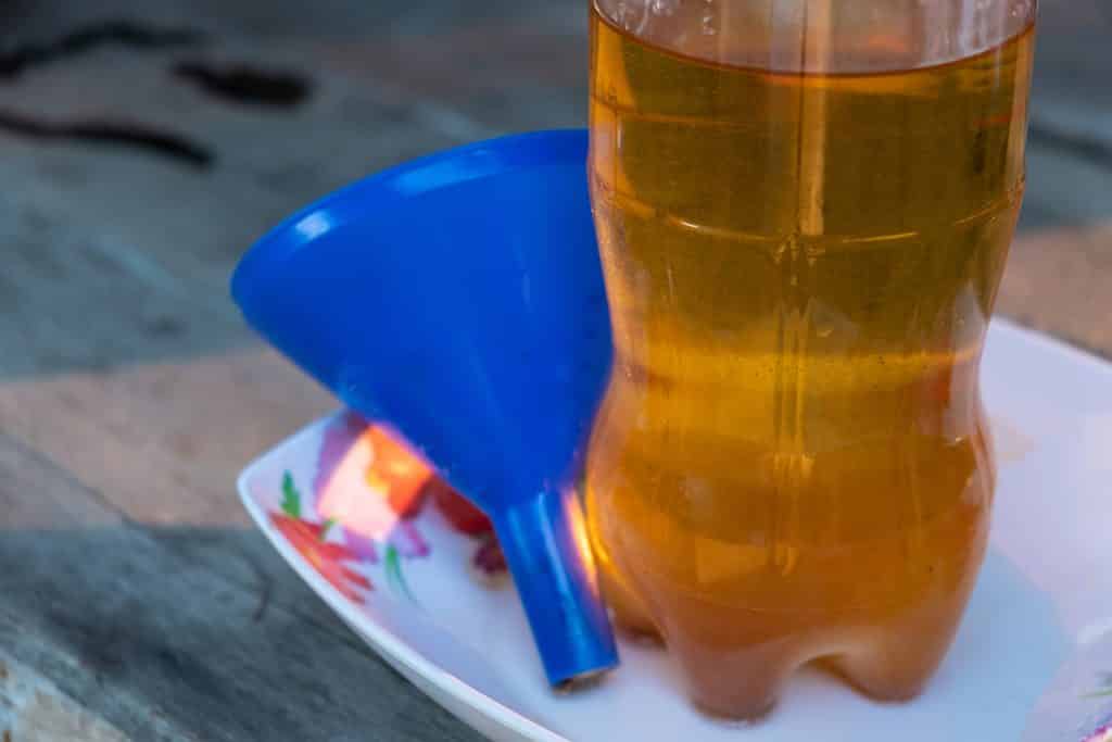 Imagem de uma garrafa transparente cheia de óleo de cozinha pronto para reuso.
