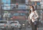 Mulher andando na rua com máscara de proteção no rosto