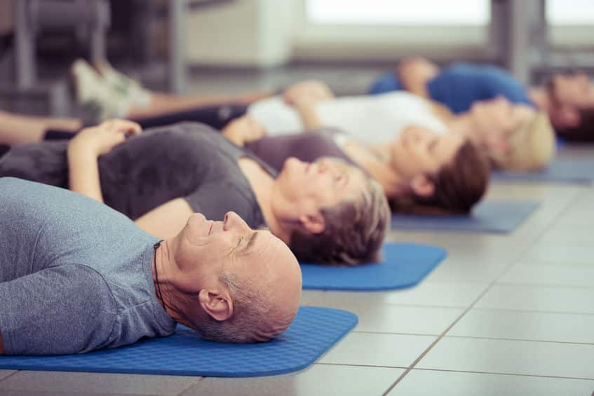 Pessoas deitadas meditando