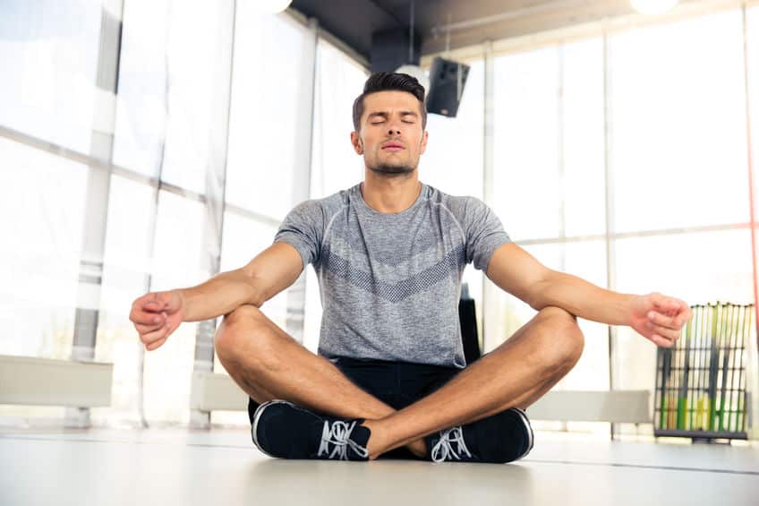 Homem meditando e caixa de som ao fundo