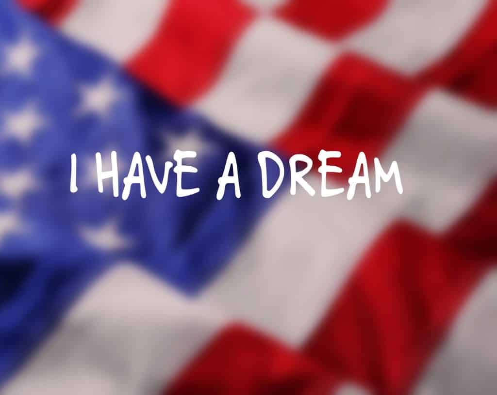 Imagem da bandeira dos Estados Unidos e sobre ela está escrita a frase de Martin Luther King: Eu tenho um sonho.