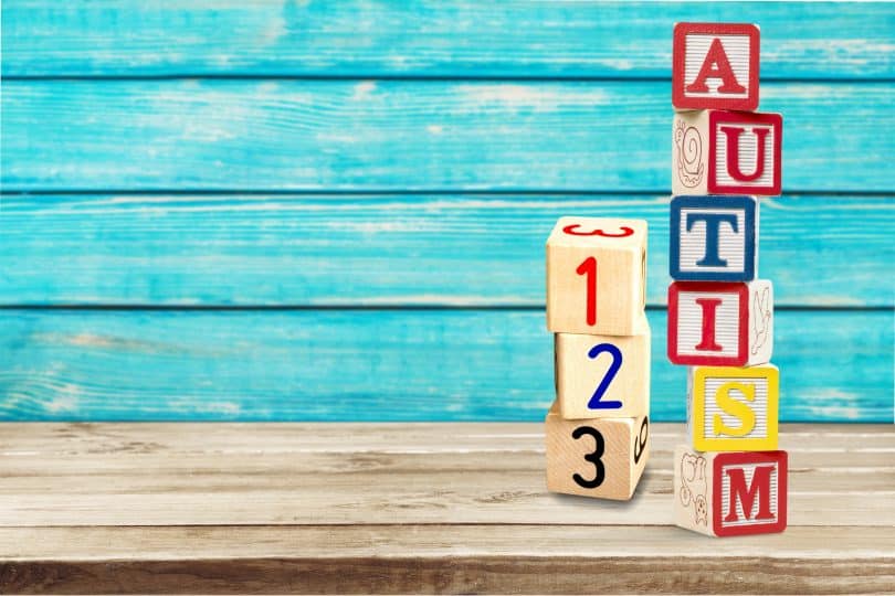 Peças de madeira formando a palavra "autism" e os números "123".