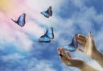 Mãos abertas libertando borboletas ao céu ensolarado.