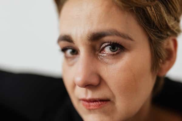 Mulher com olhos molhados e expressão de pânico