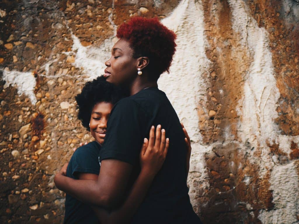 Mãe abraçando a filha.