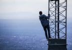 Pessoa se segurando em uma torre olhando para o mar um