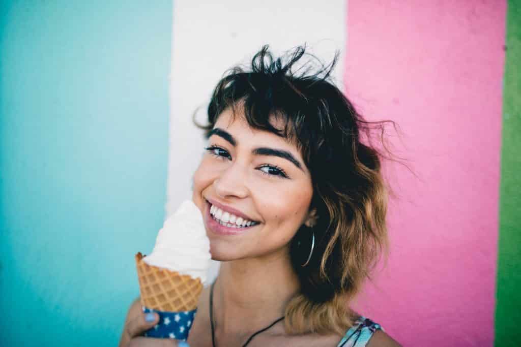 Mulher tomando sorvete sorrindo