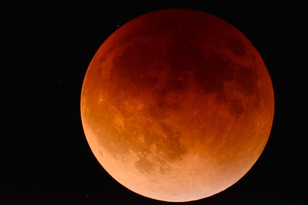Imagem do eclipse lunar. A lua está bem grande e alaranjada.