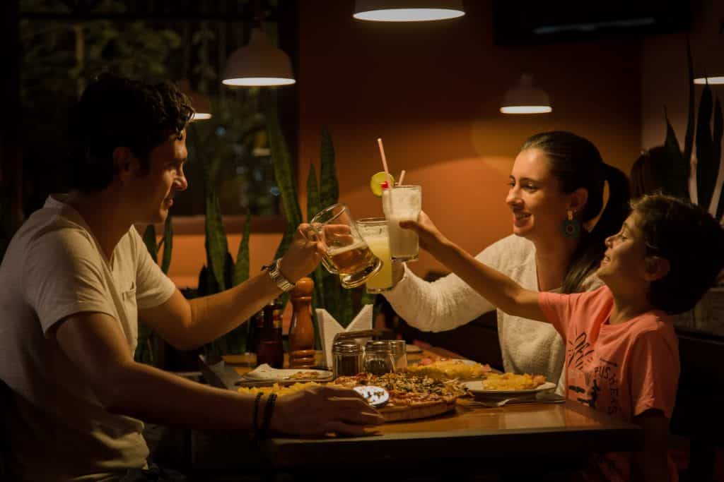 Família reunida na mesa comendo e brindando