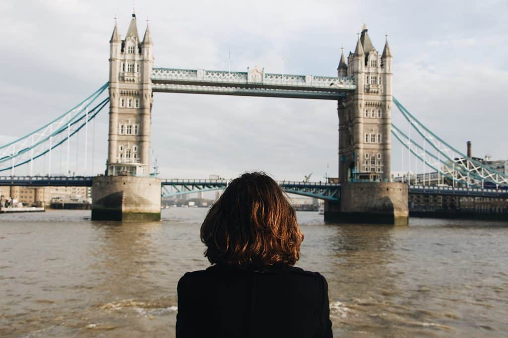 Mulher de costas em frente à London Bridge,em Londres.