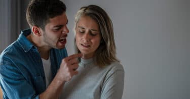 Homem discutindo com mulher enquanto aponta o dedo na cara dela