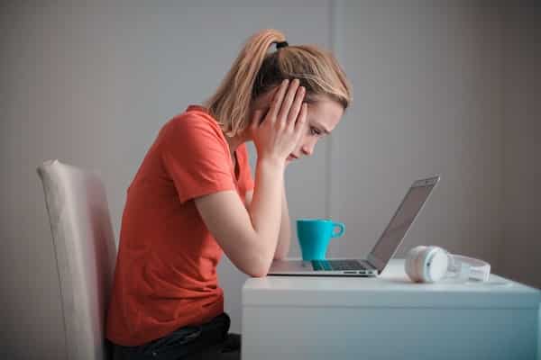 Mulher em frente ao computador com expressão desanimada
