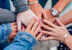 Mulheres colcoando suas mãos no centro da roda