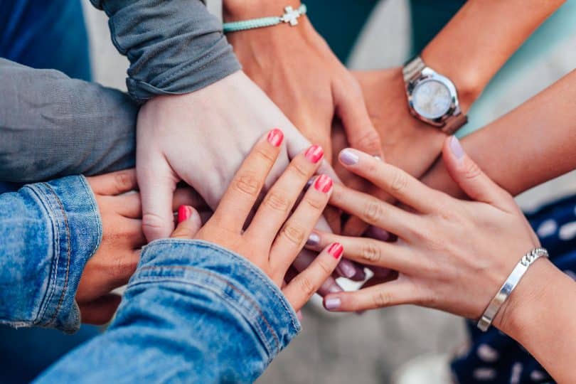 Mulheres colcoando suas mãos no centro da roda