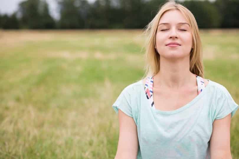 Mulher de olhos fechados meditando