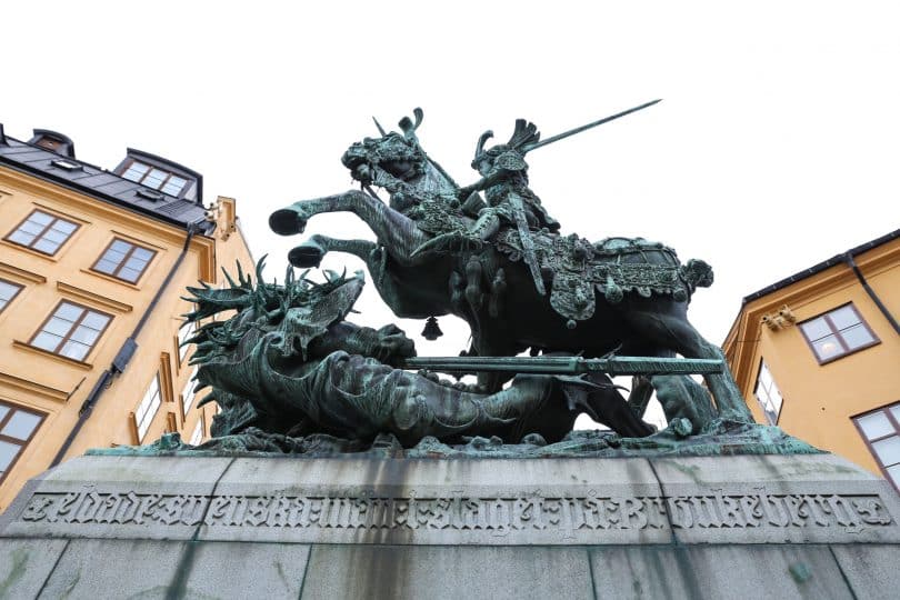 Estátua gigante de São Jorge em um cavalo, segurando sua espada, com um dragão morto embaixo.